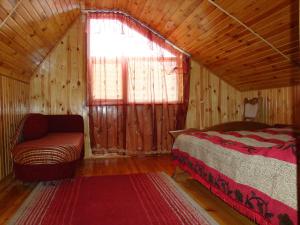 1 dormitorio con 1 cama, 1 silla y 1 ventana en Vyshenka Guest House, en Yaremche
