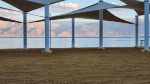 a group of umbrellas on a beach near the water at KING of the dead sea by CROWN in Neve Zohar