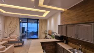 a kitchen with a sink and a living room at Grande Beach in Al Khīrān