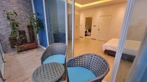 a room with two chairs and a bed and a mirror at Grande Beach in Al Khīrān