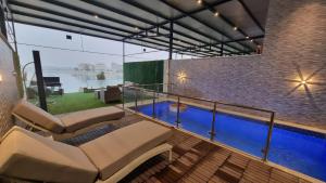 a house with a swimming pool on a balcony at Grande Beach in Al Khīrān