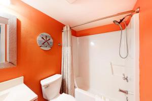 an orange bathroom with a toilet and a bath tub at Clearwater II in Gulf Shores