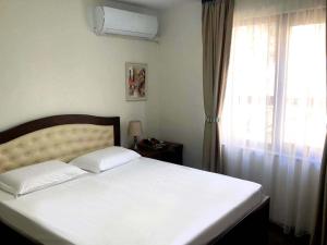 a bedroom with a white bed and a window at RELAX Apartments in HASKOVO, Apt1 in Haskovo