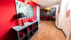 a hallway with red walls and a red wall at Hôtel Furania in Saint-Étienne