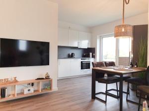 a living room with a dining room table and a kitchen at Zum Meer in Damp