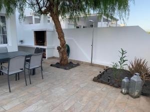 a patio with a tree and a table and chairs at Casa Acqua in Playa Honda