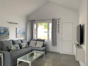 a living room with a gray couch and a glass table at Casa Acqua in Playa Honda