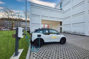 un coche eléctrico está conectado a un parquímetro en GHOTEL hotel & living Bochum, en Bochum