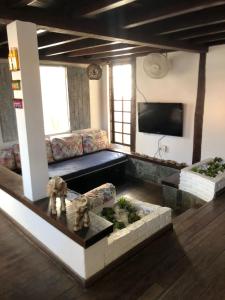 a living room with a couch and a tv at Pousada Cores da Passarela - Sob nova direção in Porto Seguro
