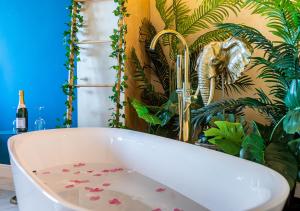 a bathroom with a bath tub with flowers on the floor at JUNGLE SUITE --- VASCA in camera in Turin
