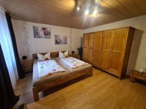 1 dormitorio con 2 camas y armario de madera en Haus Blume, en Medebach