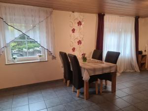 een eetkamer met een tafel en stoelen en een raam bij Haus Blume in Medebach