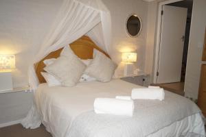 a bedroom with a white bed with white sheets and pillows at Valentines Hermanus in Hermanus