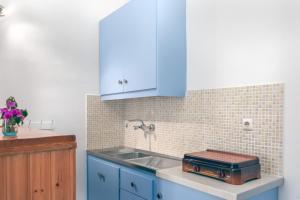 a kitchen with blue cabinets and a sink at Potamitis House in Alykes