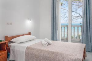 a bedroom with a bed and a large window at Potamitis House in Alykes