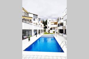 een zwembad in het midden van een gebouw bij El Oasis - Precioso apartamento cerca de la playa in Torremolinos