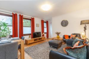 a living room with a couch and a tv at Vibrant & bright city centre apartment! in Oxford