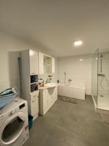een witte badkamer met een wastafel en een douche bij Stern Unterkunft bis zu 9 Betten verfügbar in Bremen