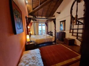 a bedroom with a canopy bed and a staircase at CHALET ELATI in Vytina