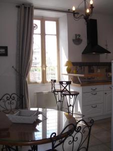 een keuken met een tafel en stoelen en een raam bij ANNECY COQUET MEUBLE t2 ENTRE STATION SKI ET LAC in Annecy