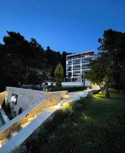 a building with lights in a park at night at Pino Boutique Hotel in Ulcinj