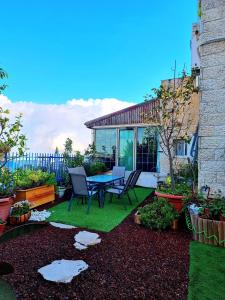 een patio met een tafel en stoelen in een tuin bij Pleasant Cozy Sunny Room with Garden in Jeruzalem