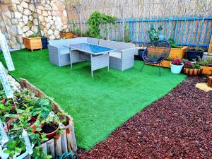 een achtertuin met een tafel en groen gras bij Pleasant Cozy Sunny Room with Garden in Jeruzalem