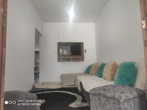 uma sala de estar com um sofá e uma televisão em Casa Souza em Ilhéus