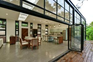 an open kitchen and dining room of a house with large windows at The River Bank, Jinja in Jinja