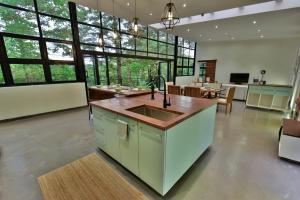 a large kitchen with a sink and a living room at The River Bank, Jinja in Jinja