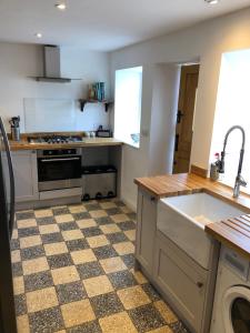 a kitchen with a sink and a stove at 3 Bedroom Cottage, Red Wharf Bay, Pentraeth, Anglesey in Pentraeth
