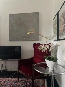 a living room with a red couch and a table with flowers at Haus zum Rhein in Lahnstein