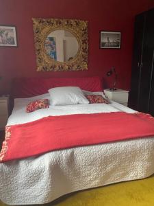ein Schlafzimmer mit einem großen Bett mit einer roten Wand in der Unterkunft Haus zum Rhein in Lahnstein