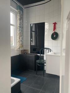 ein Badezimmer mit einer Badewanne, einem Waschbecken und einem Stuhl in der Unterkunft Haus zum Rhein in Lahnstein