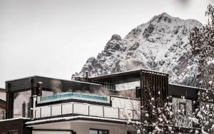 a building with a mountain in the background at Stoa - Elegant & Romantic Guest House - "Adults only" in San Vigilio Di Marebbe
