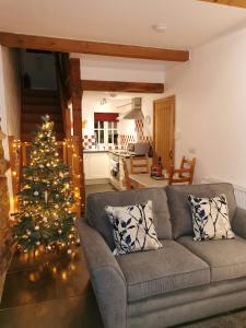 a living room with a christmas tree and a couch at Rainors farm cottage in Gosforth