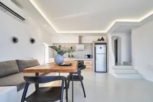 a kitchen and living room with a wooden table and chairs at Teal Rock Mykonos in Ano Mera