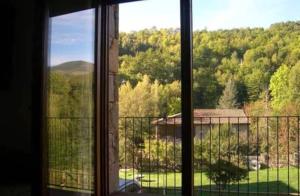 uma janela com vista para um jardim a partir de uma casa em LLANARS, en Vall de CAMPRODON Vistas Montaña de frente, ASCENSOR, Orientación Sur, Chimenea, WIFI, MOLLÓ PARK, VALLTER, HÍPICA, GOLF em Llanars
