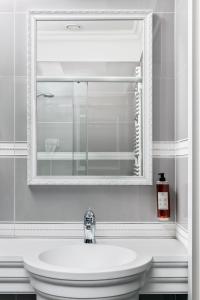 a bathroom with a white sink and a mirror at Merci Boutique Hotel in Kraków