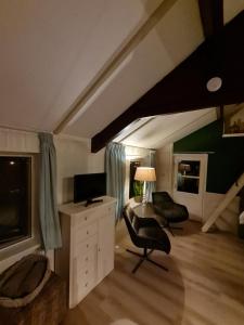 ein Wohnzimmer mit einem Schreibtisch und einem Stuhl in der Unterkunft B&B Helene Hoeve in Venhorst