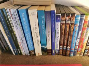 a row of books sitting on a shelf at Rainors farm cottage in Gosforth