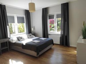 1 dormitorio con 1 cama grande y 2 ventanas en Willa Klonowa, en Wisła