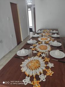 una mesa larga con platos y sombrillas. en Casa Souza en Ilhéus