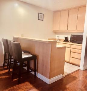 a kitchen with a bar with chairs and a microwave at Howard Johnson by Wyndham Buena Park in Buena Park