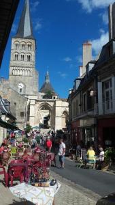 un grupo de personas caminando por una calle con una iglesia en Gîte de la Galerie du Pont, en La Charité-sur-Loire