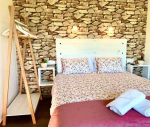 a bedroom with a large bed with a stone wall at Casa nueva en Vigo con Jacuzzi y chimenea in Pontevedra