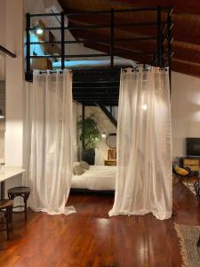 a bedroom with white curtains and a bed in the background at Rooftop Alfonso in Zaragoza