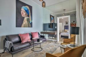 a living room with a couch and a painting at Beaumont Cottages 2 by CTHA in Cape Town