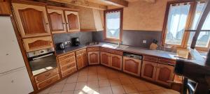 a large kitchen with wooden cabinets and windows at Lou Francese in Ceillac