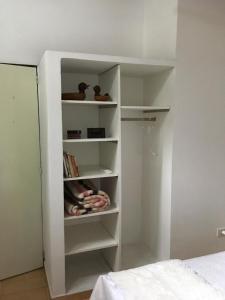 um armário branco com prateleiras num quarto em Espacio Arte em Posadas